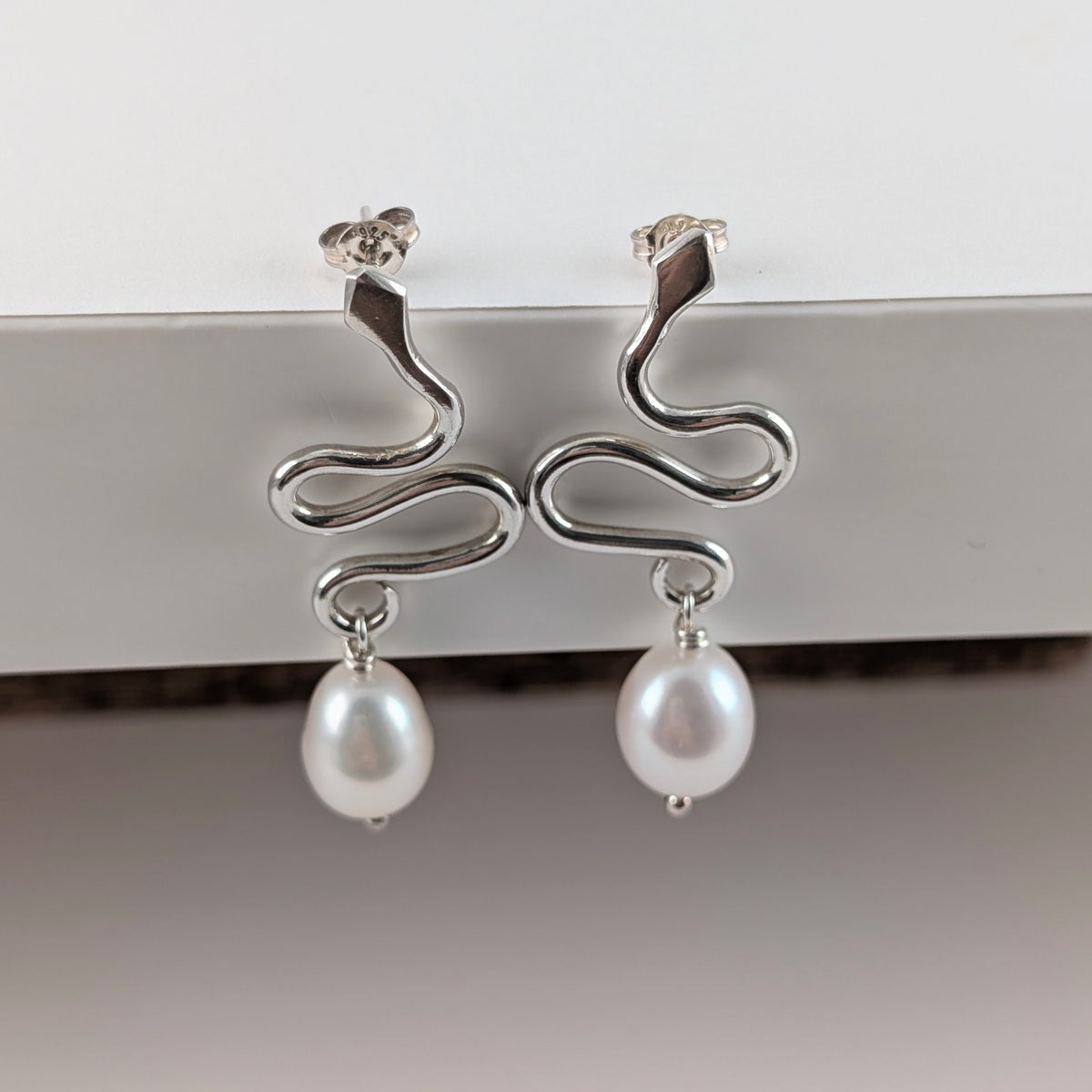 Large snake stud earrings with white baroque pearls